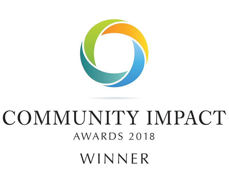 Logo with a colorful circular design above the text Community Impact Awards 2018 Winner.